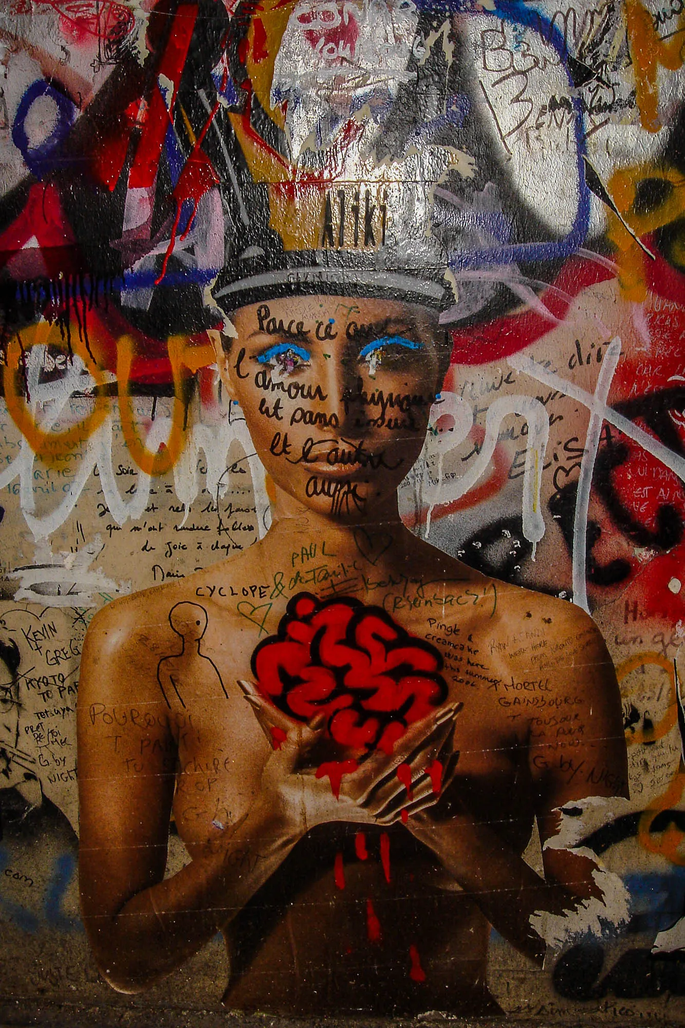 Grafiti cenering on an image of a nude realistic woman from the waist up, her chest covered by her arms holding a simple illustrative brain with dripping blood. Her head is cut off at the forehead with an illustrative crown.